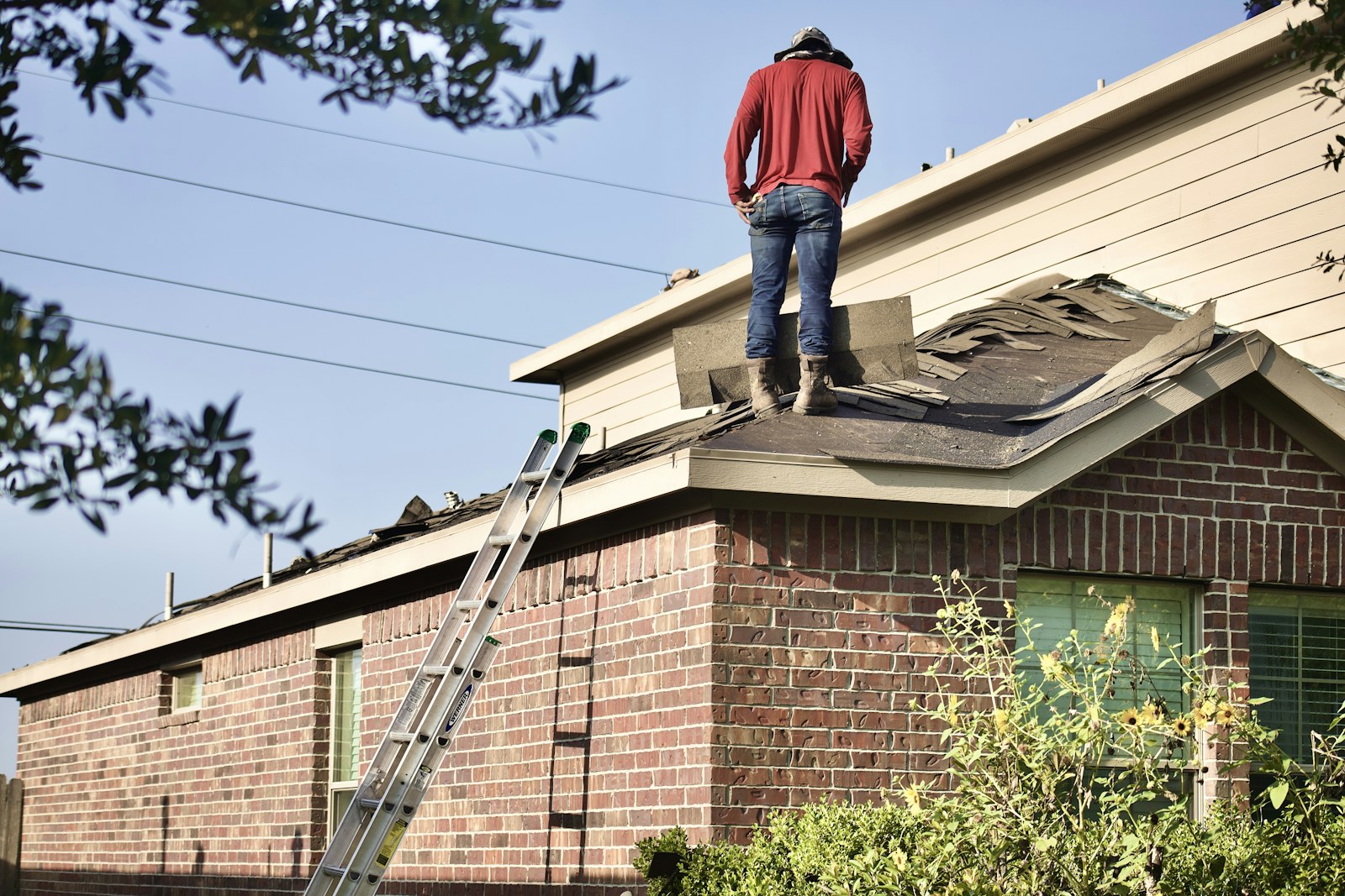 Gutter professional working safely from a ladder at a residential roofline
